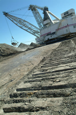 Caterpillar tracks of dragline leading up to working machine shot vertical - Mining Photo Stock Library