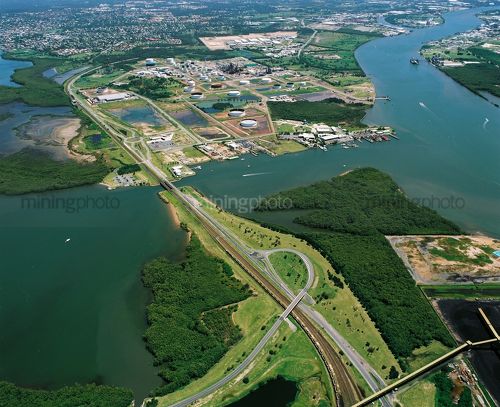 Aerial view of city freeway, water treatment plant and mangrove river. - Mining Photo Stock Library