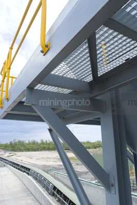 Elevated platform with yellow guard rails above overland coal conveyor - Mining Photo Stock Library