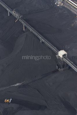 Vertical aerial photo of dozer stockpiling coal into hopper at coal terminal.  overhead conveyors.  coal to all edges of photo. - Mining Photo Stock Library