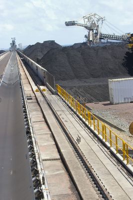 Coal spreader and reclaimer at terminal.  shot looking along tracks with coal stockpiles adjacent. - Mining Photo Stock Library