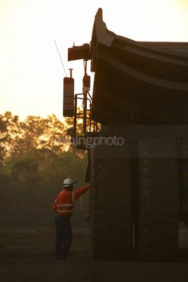 Mine haul truck driver in ppe having a discussion at the end of the shift.  haul truck go line in dawn light. - Mining Photo Stock Library