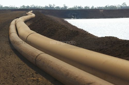 Water pipes to tailings holding dam on a mine site. - Mining Photo Stock Library