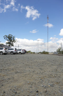 Communications tower in the car park of remote mine site. light vehicles parked up.  generic photo showing site office buildings.  vertical format photo. - Mining Photo Stock Library
