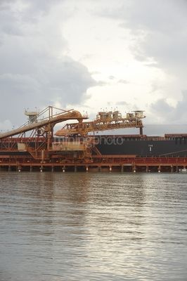 Shiploader loading product into a ship at the port of a mine site. - Mining Photo Stock Library