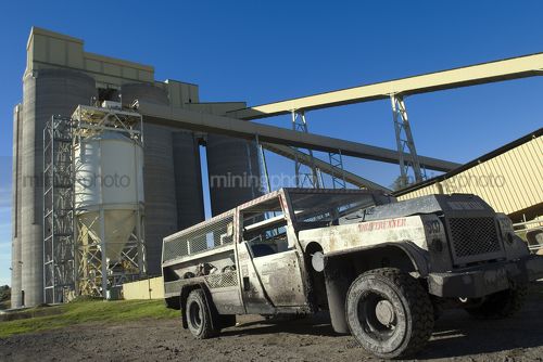Drift runner underground coal vehicle  parked in front of storage tanks at mining site. - Mining Photo Stock Library