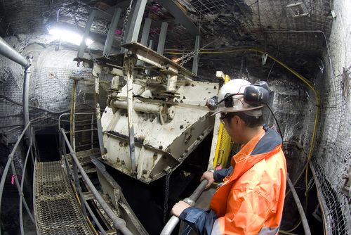 Underground coal mine engineer in full PPE observing machinery operating in under ground environment. - Mining Photo Stock Library