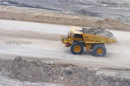 Aerial photo of haul truck moving with overburden on haul access road in open cut mine. - Mining Photo Stock Library