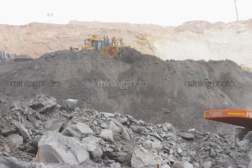 Dozer pushing overburden into a stockpile in open cut mine site.  very generic photo with room for copy. - Mining Photo Stock Library