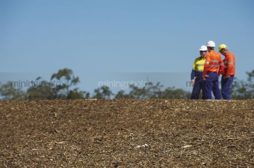 Three mine site workers in full PPE in discussion.     - Mining Photo Stock Library