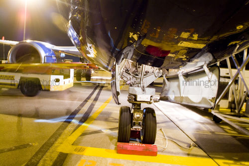 Wheels of large plane on tarmac at airport. shot at night - Mining Photo Stock Library