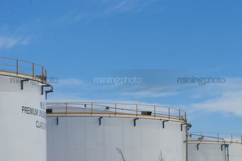 Photo of large fuel storage silos.  blue sky behind. - Mining Photo Stock Library