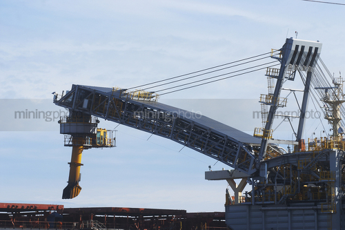 Shiploader loading product into a ship.  close up of actual loading. - Mining Photo Stock Library