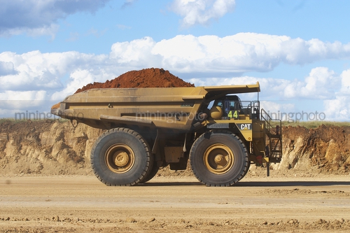 Side on photo of loaded 789 cat haul truck at open cut mine site. - Mining Photo Stock Library