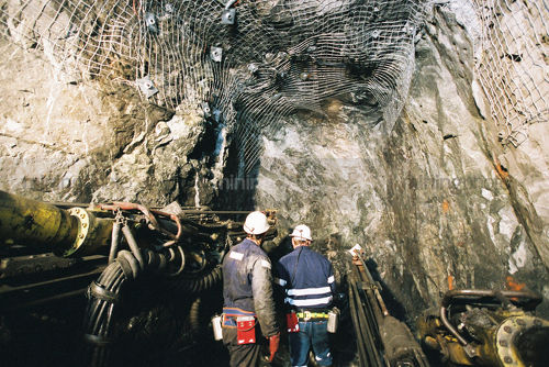 2 underground mine workers inspect machinery and drilling area. - Mining Photo Stock Library