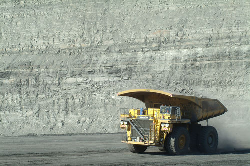 Loaded haul truck moving along opencut mine site floor - Mining Photo Stock Library