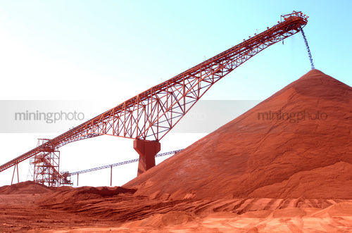 Great shot of large conveyor stockpiling red dirt product. - Mining Photo Stock Library