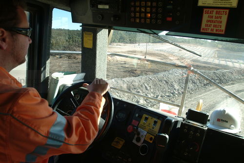 Haul truck driver inside cab driving past shots being laid. shot from inside the cab during a rotation. - Mining Photo Stock Library