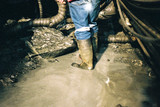 Mining Photo Stock Library - underground mine worker in gumboots organising water pump system.  shot from behind and from the waist down. ( Weight: 1  New Image: NO)