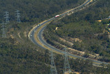 Mining Photo Stock Library - trucks on highway through forest with electricity supply power lines adjacent.  aerial shot. ( Weight: 2  New Image: NO)