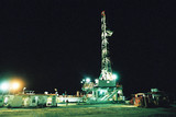 Mining Photo Stock Library - desert oil rig shot at nigth under lights with a single worker in the shot for scale. ( Weight: 3  New Image: NO)