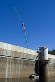 Mining Photo Stock Library - vertical shot close up of dam wall and construction crane with maintenance boat in the water. deep blue sky. ( Weight: 4  New Image: NO)