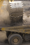 Mining Photo Stock Library - close up of digger bucket loading haul truck with overburden in open cut mine.  lots of dust. ( Weight: 3  New Image: NO)