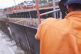 Mining Photo Stock Library - infrastructure worker setting formwork on site with workers in the background.  shot from behind. ( Weight: 1  New Image: NO)
