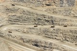 Mining Photo Stock Library - many haul trucks loaded and empty weaving their way up steep haul road on way out of open cut gold mine. ( Weight: 1  New Image: NO)