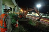 Mining Photo Stock Library - project manager in full PPE overseeing night works on train line with excavator.  shto at night with construction lighting. ( Weight: 1  New Image: NO)