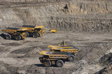 Mining Photo Stock Library - 4 four haul trucks parked at go line in open cut coal mine.  worker in full PPE gives scale of machines.   ( Weight: 1  New Image: NO)