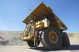 Mining Photo Stock Library - dramatic photo of a haul truck in open cut coal mine.  shot from ground level almost under front wheel.  blue sky behind. ( Weight: 1  New Image: NO)