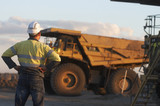 Mining Photo Stock Library - worker in full PPE with hands on hips observing haul trucks at the go line.  shot in the late afternoon light. ( Weight: 1  New Image: NO)