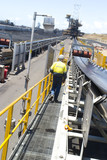 Mining Photo Stock Library - mine supervisor in full PPE on walkway next to coal conveyor at a coal terminal. shot from behind, cannot see the persons face. ( Weight: 1  New Image: NO)
