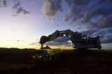 Mining Photo Stock Library - dusk photo of excavator loading overburden into haul truck in open cuit mine site. machines with lights on and great colour in the sky.  generic production image. ( Weight: 1  New Image: NO)
