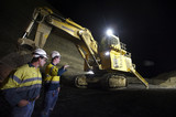Mining Photo Stock Library - shot at night, two 2 mine site workers in full PPE down in the open cut coal mine pit discussing next move with large excavator with lights on in the background. ( Weight: 1  New Image: NO)