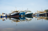 Mining Photo Stock Library - fishing trawler boats moored in a clean water harbour.  photo taken at water level with blue sky behind. ( Weight: 1  New Image: NO)