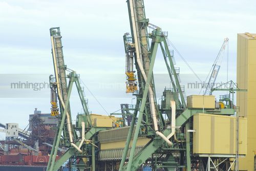 Bulk ship loaders at terminal with ship in background. shot up close. - Mining Photo Stock Library