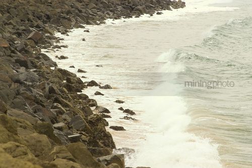 Rock retaining wall surf ocean power rocks - Mining Photo Stock Library