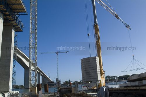 Cranes and construction work adjacent to major artillery vehicle bridge. - Mining Photo Stock Library