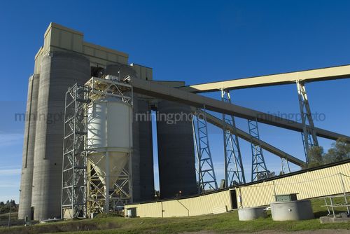 Large coal storage silo towers at power station.  many covered conveyors attached. - Mining Photo Stock Library