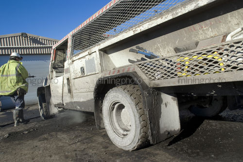 Specialised underground mine vehicle being filled up with fuel by worker in full ppe. - Mining Photo Stock Library