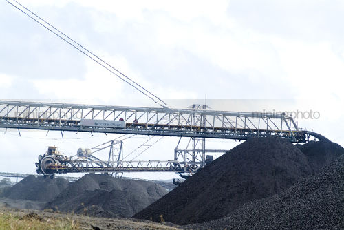 Coal loaders and reclaimers working stockpiling at port facility - Mining Photo Stock Library