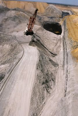 Dragline working in open cut coal mine pit with coal seam and high walls behind. vertical shot from the air. - Mining Photo Stock Library