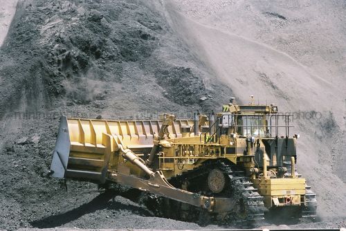 Bulldozer with huge bucket stockpiles coal at mine site. - Mining Photo Stock Library