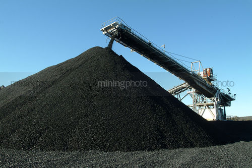 Track conveyor loader stockpiling coal - Mining Photo Stock Library