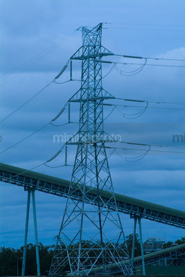 Electricity tower with coal conveyors in foreground.  blues wash through image. - Mining Photo Stock Library