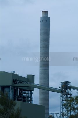 Smokestyck at power station close up.  coal conveyors and plant adjacent.  blue wash through image. - Mining Photo Stock Library