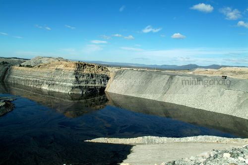 Water storage dam at open cut coal mine with high walls. - Mining Photo Stock Library