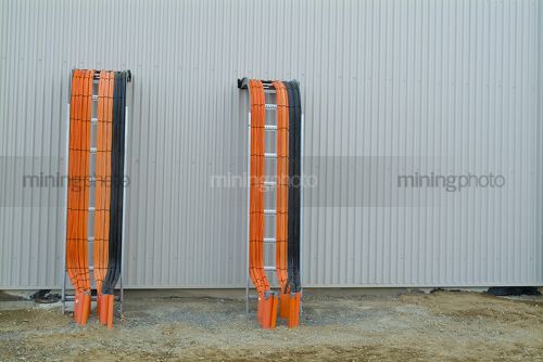 Electrical conduit and power cables exiting exterior of a building - Mining Photo Stock Library